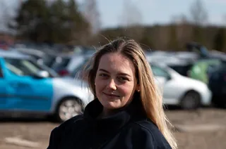 Kvinne med lyst hår og svart jakke